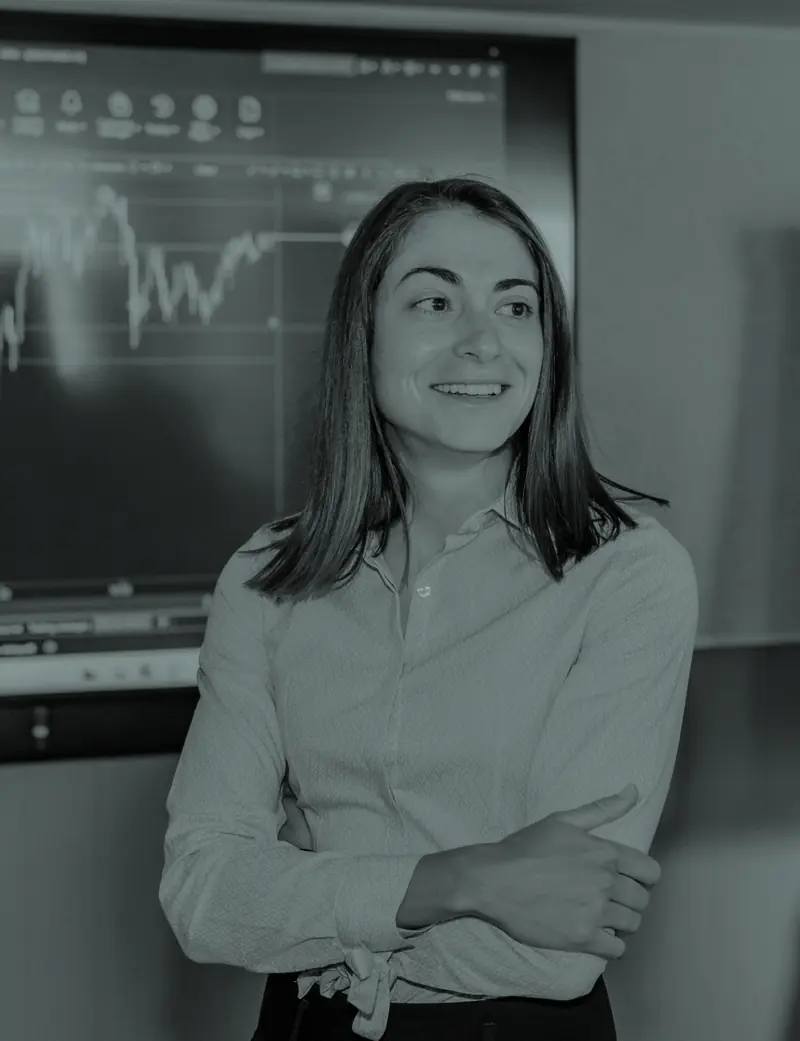 Cátia Fernandes, CEO e coach da DROPOWER, numa sessão presencial com um gráfico de mercado ao fundo